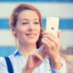 Handy-Nutzerin mit EMF-Schutzfolie auf Smartphone, Schutz vor elektromagnetischer Strahlung, moderne EMF-Schutztechnologie für Gesundheit, mobile EMF-Schutzlösungen.