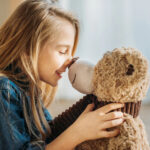 Mooi meisje omarmt knuffeldieren, emotionele band, liefde en geborgenheid, kinderspeelgoed, natuurlijk licht, welzijn, positieve sfeer, kinderlijke vreugde, vriendschap, knuffeltijd, gezinsleven, kinderlachen, warm licht, ouder-kind interactie, kinderlijke genegenheid, emotionele scène, kinderlijk geluk, speeltijd, thuiscomfort, emotionele foto, ontwikkelingsfase, kinderlijke fantasie, geborgenheid, liefde voor knuffeldieren, kinderlijke vreugde, gezinsmomenten, kinderlijke glimlach, romantisch beeld, kinderlijke binding, kinderlijke spel.