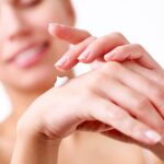 Hautpflege mit EMF-Schutz, Frau cremt ihre Haut, natürliche Schutz vor elektromagnetischer Strahlung, Alltag, Gesundheit, minimalistische Umgebung.