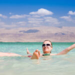 Person entspannt sich schwimmend im Wasser.