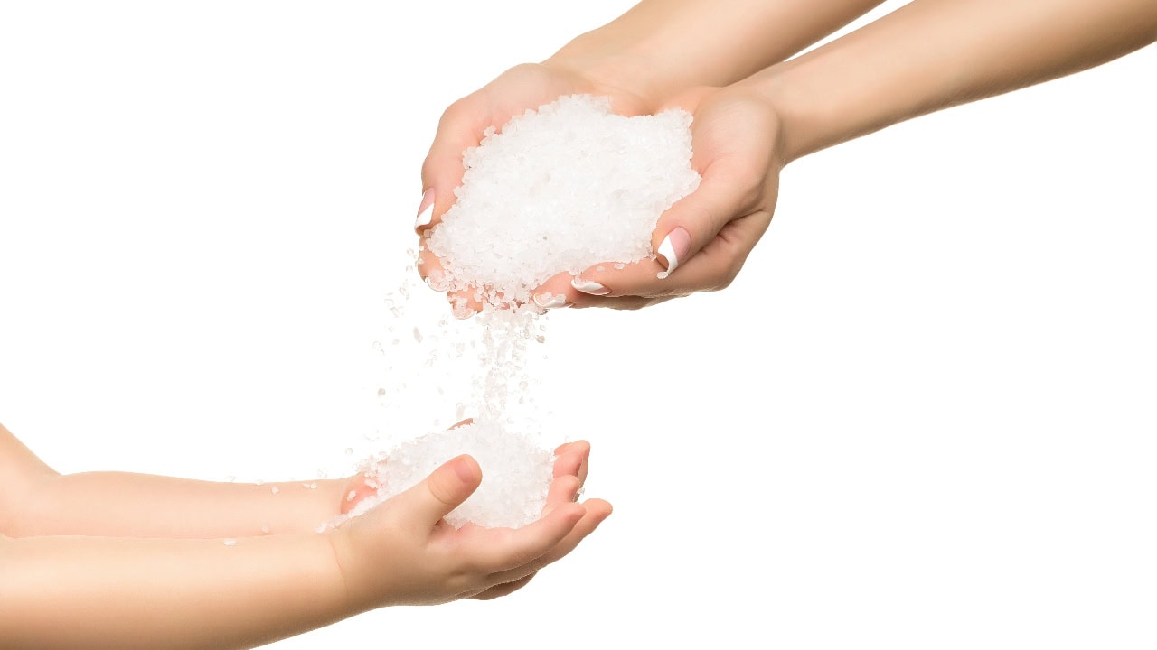 Salt i händerna, omgiven av vita kristaller, symboliserar naturliga skyddsåtgärder mot elektromagnetiska fält.